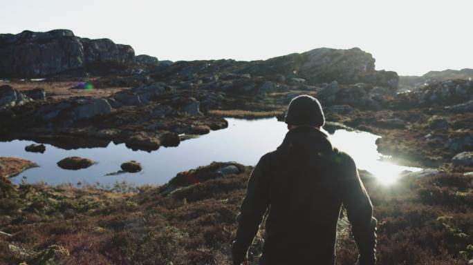 男子户外探险：在挪威徒步旅行，在湖边的山上