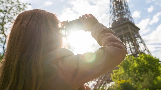 巴黎一名妇女用智能手机拍摄埃菲尔铁塔