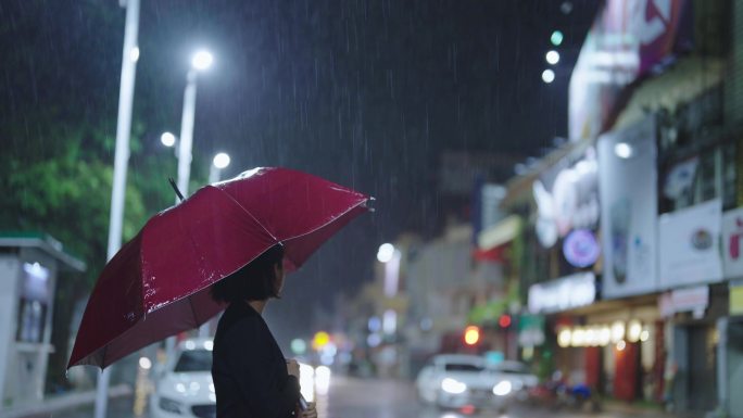 雨中，一个亚洲女人撑着伞。