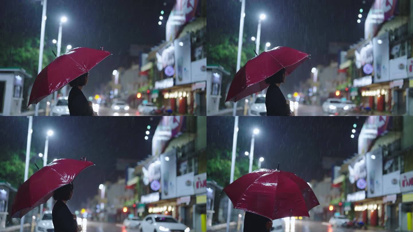 雨中，一个亚洲女人撑着伞。