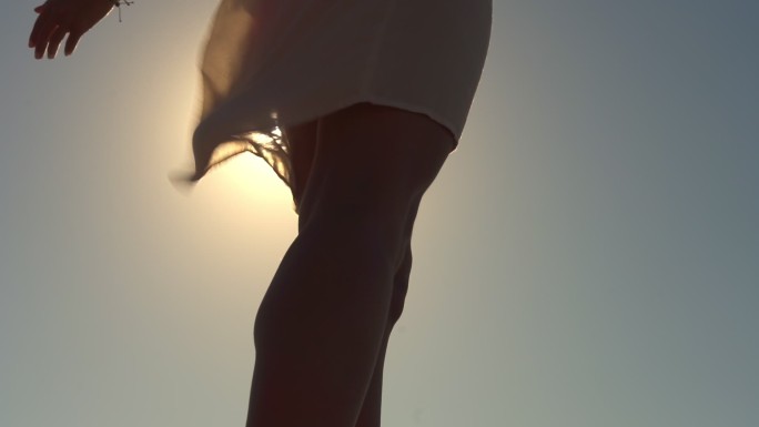 一位年轻女子在海滩上张开双臂享受微风