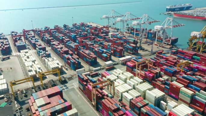 鸟瞰集装箱货船在码头商业港口的工作起重机桥上装载集装箱，用于商业物流、进出口、航运或货运。