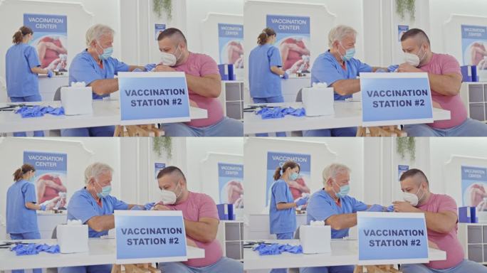 一名医护人员在接种中心为一名男子注射新冠疫苗
