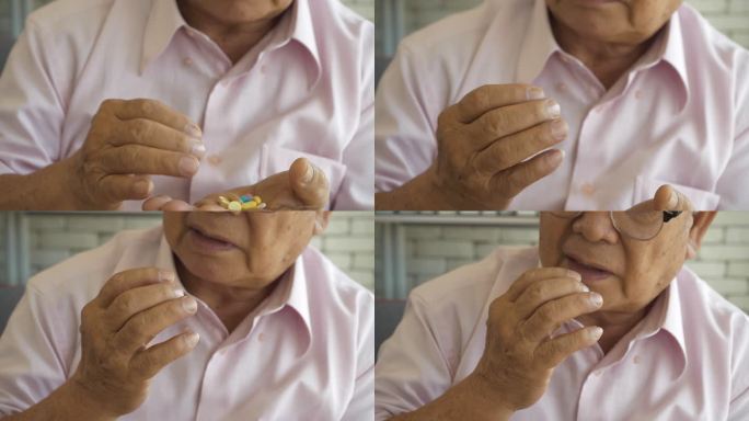 一名患有帕金森症、双手颤抖的亚裔老人试图服用这些药片。