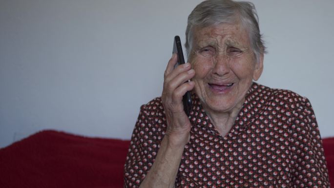 一位上了年纪的女士在智能手机上微笑