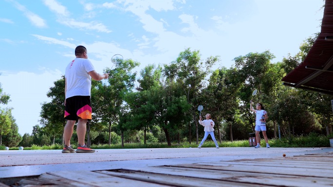 4K升格实拍在公园打羽毛球的父女三个人