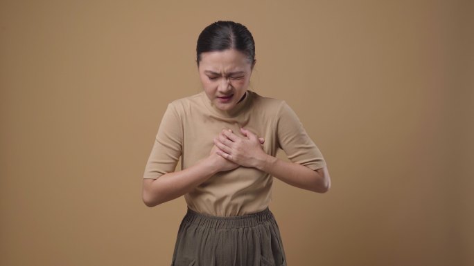 一位亚洲女性胸痛是孤立的背景。4K视频