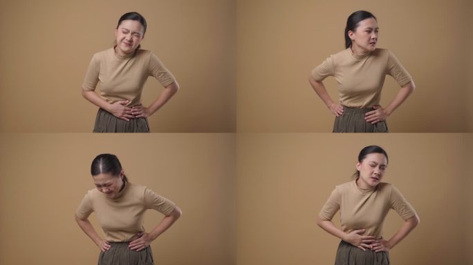 一名亚裔女性胃痛，背景是孤立的。4K视频