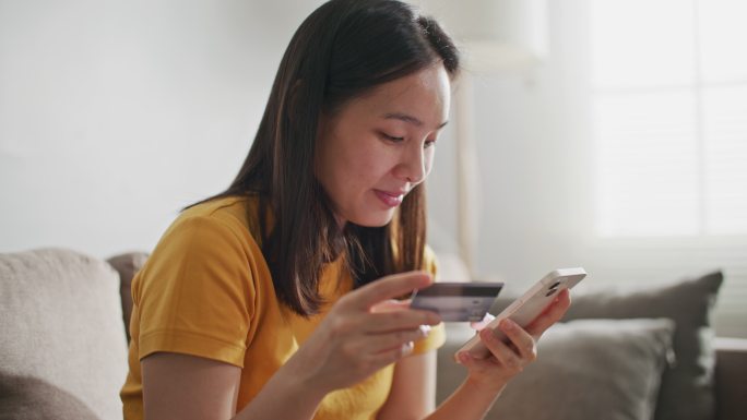 女性使用信用卡在智能手机上购物