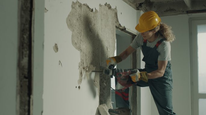 建筑工人正在用电钻拆除墙壁