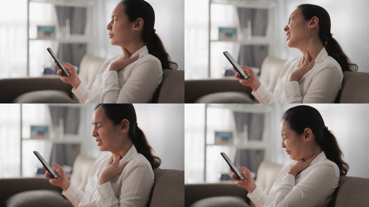 一名妇女在使用智能手机时咳嗽