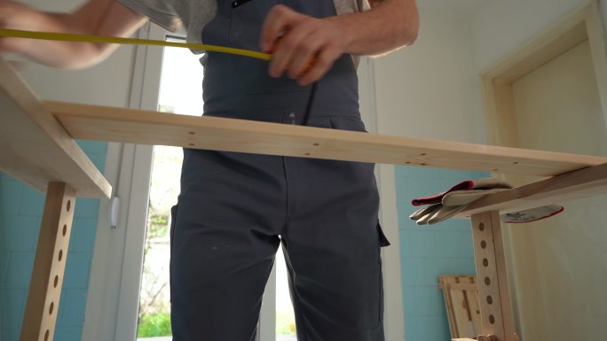 无法辨认的木匠用钢笔在木头上标出长度
