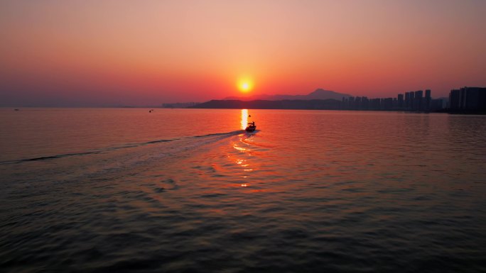 航拍夕阳下的大海和船，十里银滩
