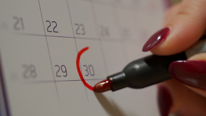 在日历上设置一个重要的日期，用红铅笔标记一个月的一天，代表组织时间和日程安排。