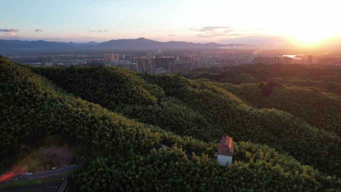 黄昏航拍从竹林飞到城市