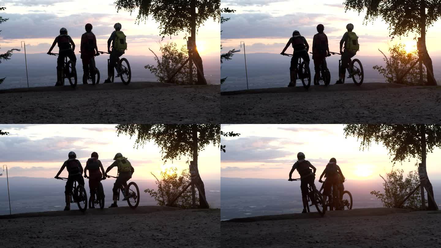三个朋友在日落时开始了一次下坡山地自行车冒险