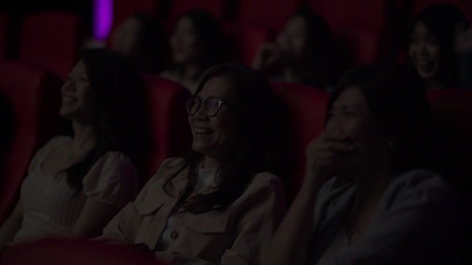 亚裔中国成熟女性和她的朋友在电影院看电影