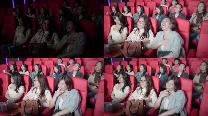 亚裔中国女性朋友在电影院看电影时大笑