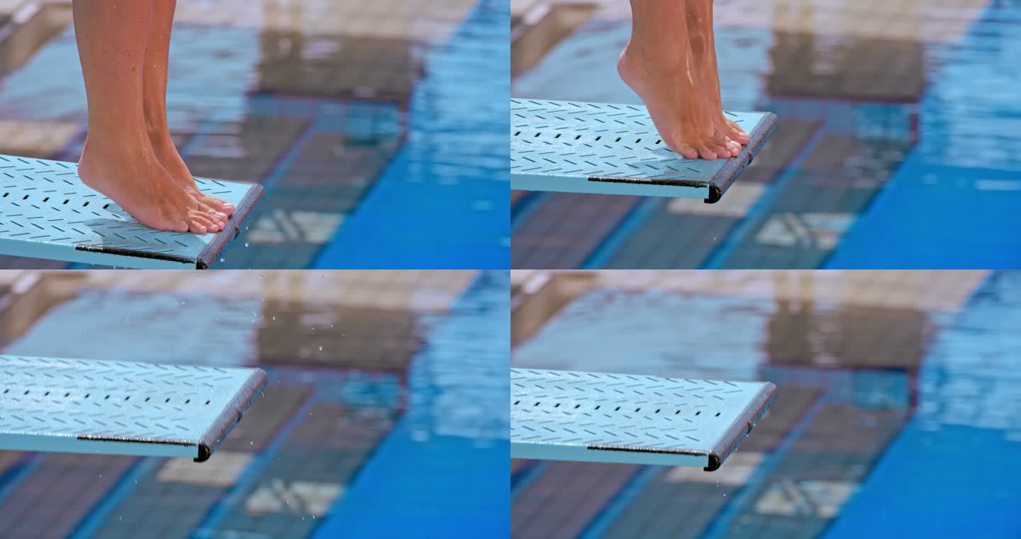 一名女潜水员从跳板上跳入游泳池的脚