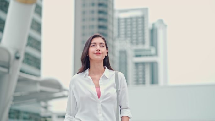 女商人在现代城市里使用电话和步行上班