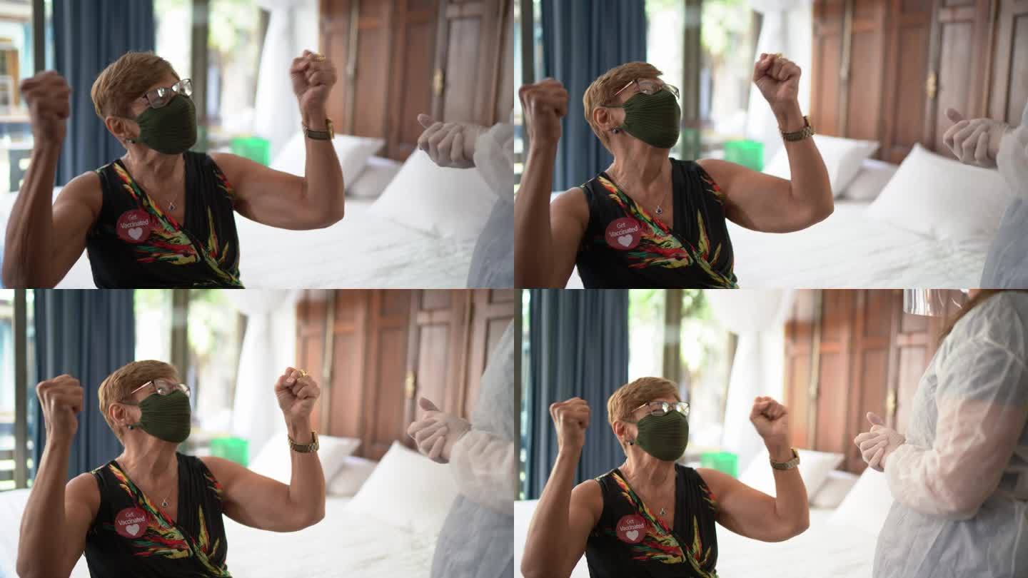 一位老年妇女戴着口罩在家里接种疫苗后庆祝