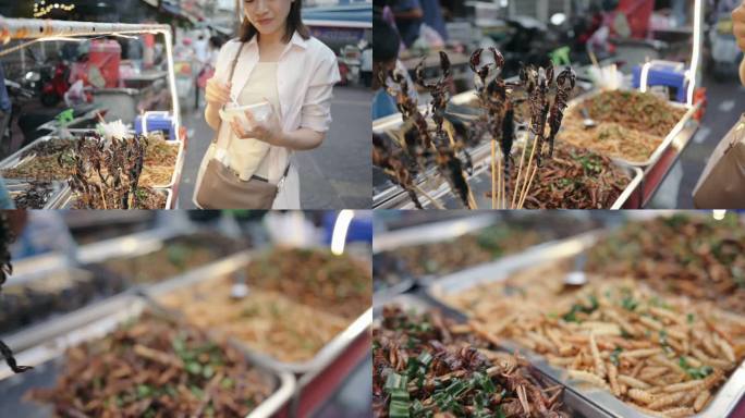 在泰国曼谷的yaowarat当地街头食品市场，年轻的亚洲当地人吃着异国风味的街头食品：炸虫、蚱蜢、蝎
