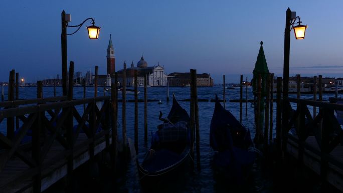 日出时威尼斯的贡多拉，背景是圣乔治·马吉奥雷塔利岛