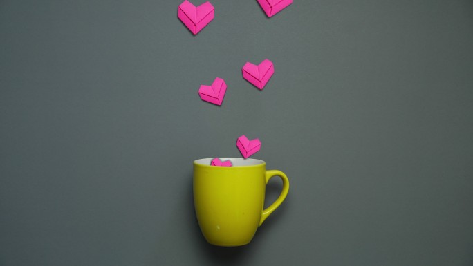 咖啡杯上的粉红色心形纸艺术。