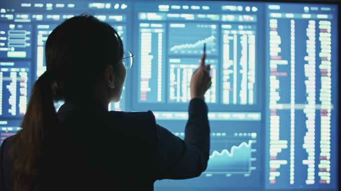 财务顾问在大型计算机显示器或监视器上分析数据、财务数字。