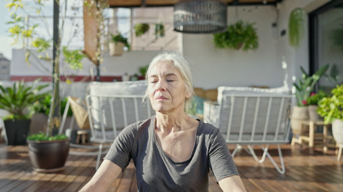 60年代中期的女人在阳光甲板上户外做瑜伽