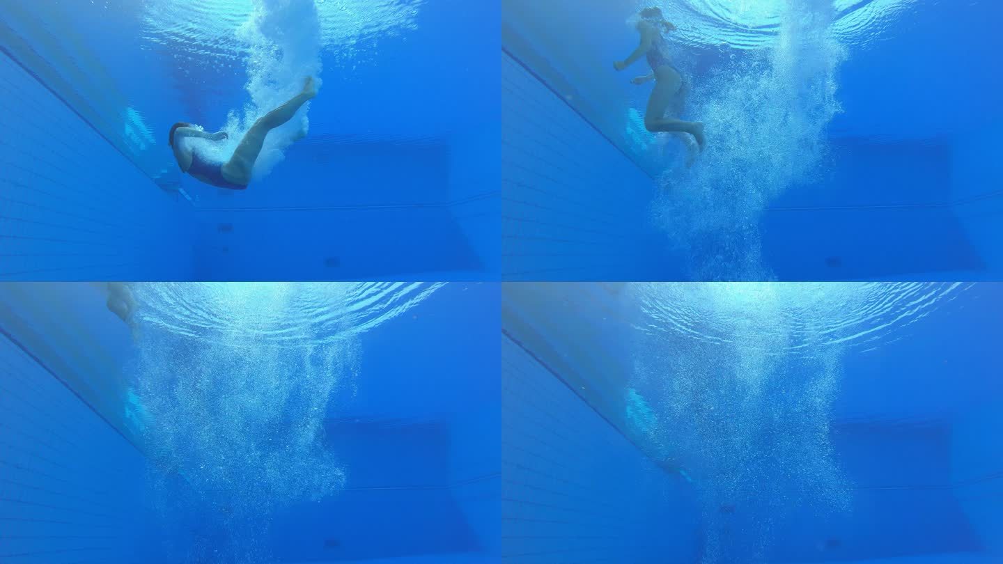 SLO-MO-LD水下视图：一名女跳水运动员降落在游泳池中，在一团气泡中旋转