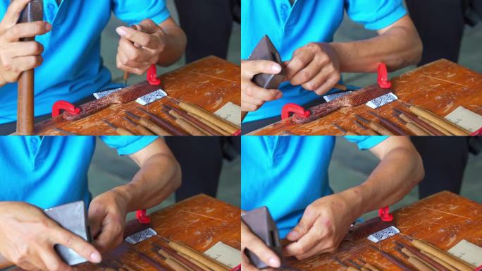 一个手工拙劣的手工业人在雕刻梳子