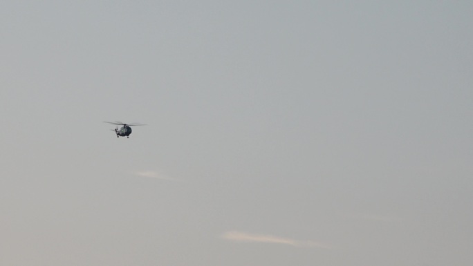 日落余晖和空中飞过的直升机