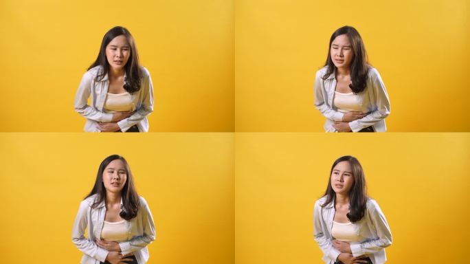 女性胃痛：黄色背景上孤立的疼痛