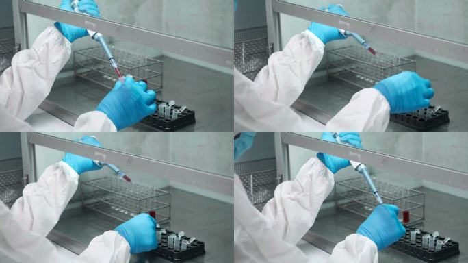 科学家在无菌室穿着防护服，在实验中使用移液管