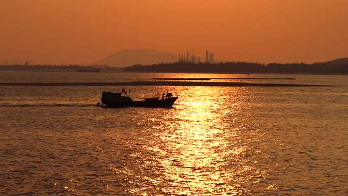 傍晚海边橙色天空小渔船回港海天一色