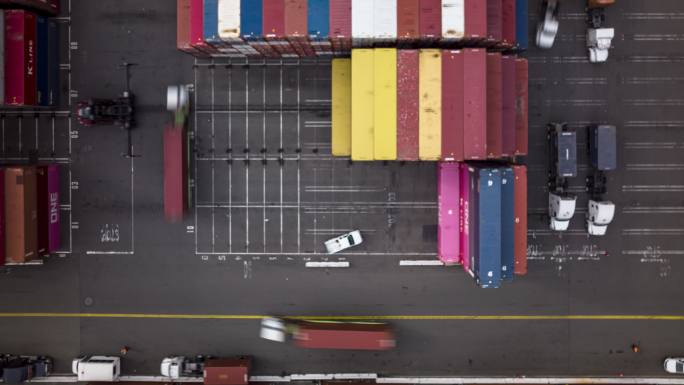 卡车排成一排在运输码头的顶部装卸车上卸货-延时