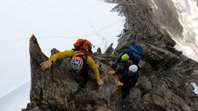 在欧洲阿尔卑斯山上攀登尖峰的专业高级登山者。用绳子。鸟瞰图