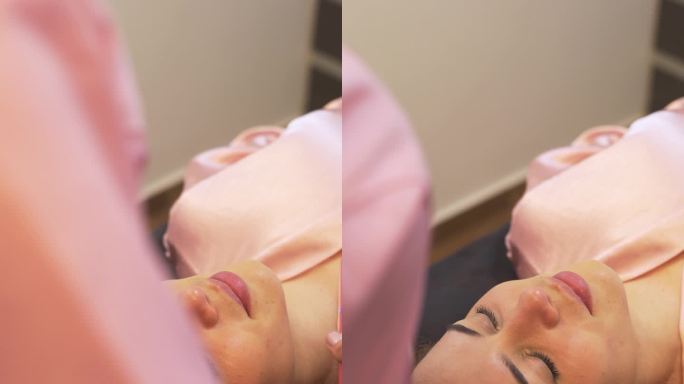 职业女性美容师在客户脸上进行美容治疗