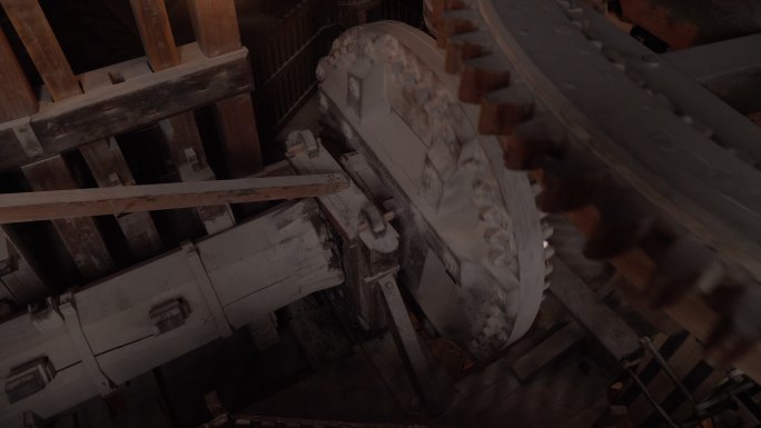 在恶劣天气下，自动传统设备内部的人造齿轮与荷兰风车内部一起粉碎，木质结构滚压和研磨，高角度平移视图。