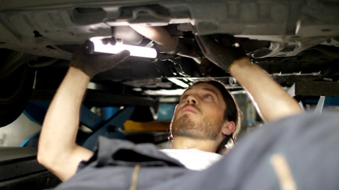 在汽车维修厂维修车辆的技工。