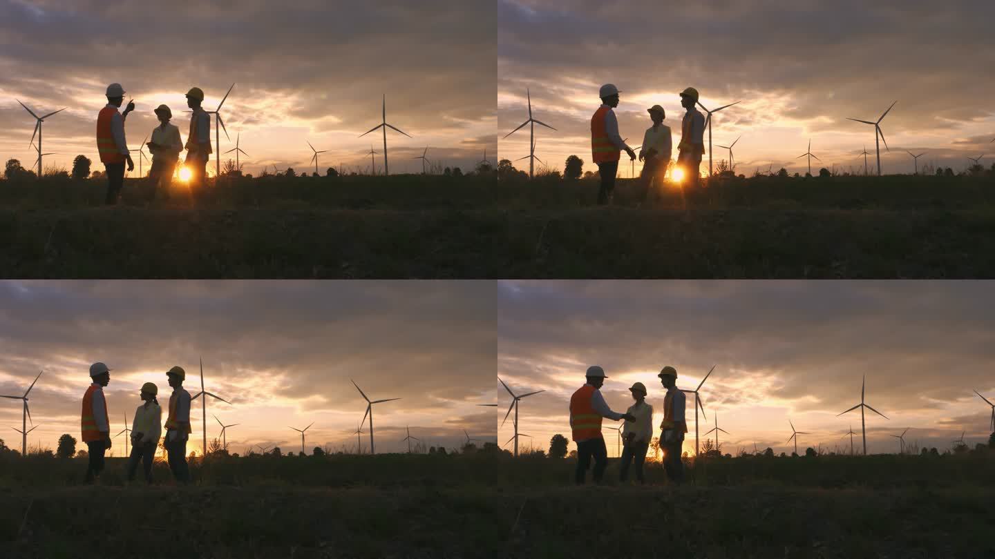 剪影：在风力发电厂从事规划工作的技术人员、工程师和工人组成的亚洲团队