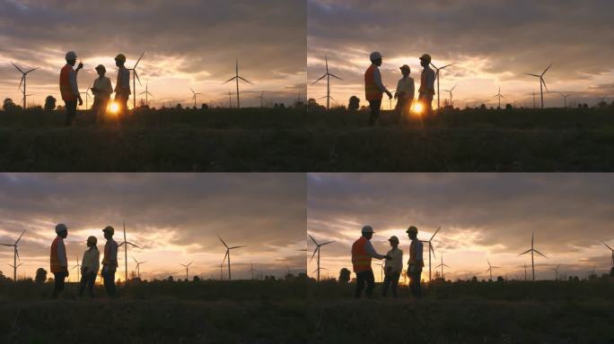 剪影：在风力发电厂从事规划工作的技术人员、工程师和工人组成的亚洲团队