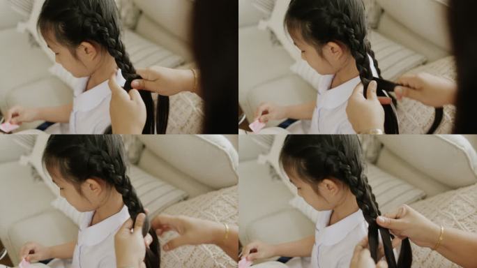 妈妈用爱为女儿手工编织头发。