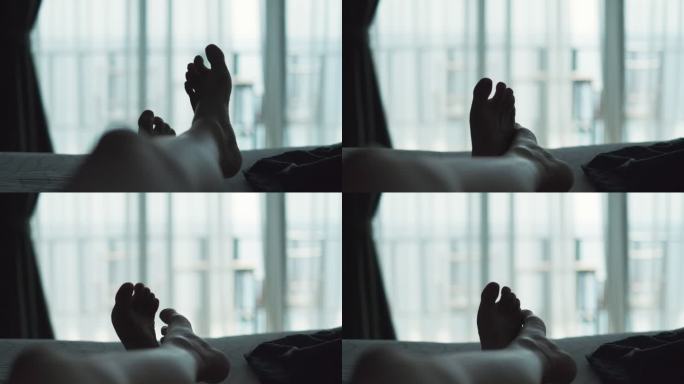 在度假期间，放松的女人躺在床上的毯子上，交叉腿，在酒店度假区看风景