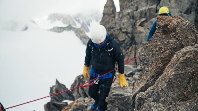 在欧洲阿尔卑斯山上攀登尖峰的专业高级登山者。用绳子。鸟瞰图