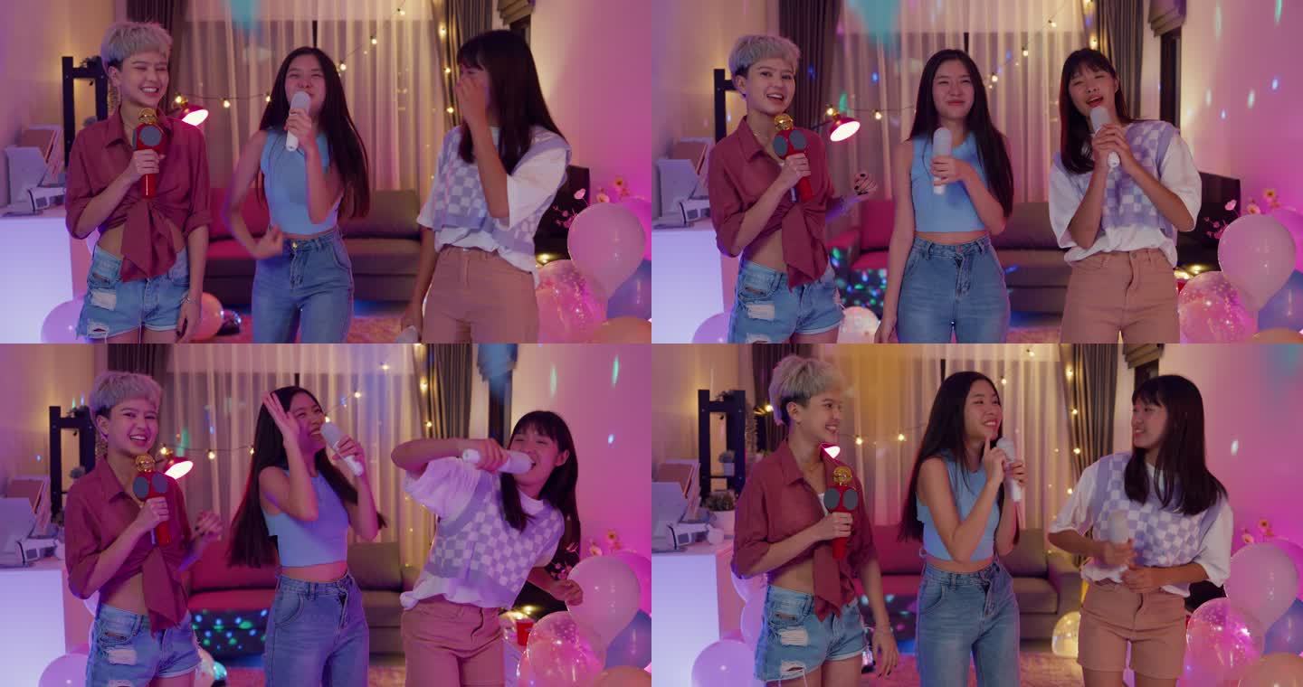 年轻的亚洲女性朋友在晚上的多彩家庭聚会上唱卡拉OK，玩得很开心。