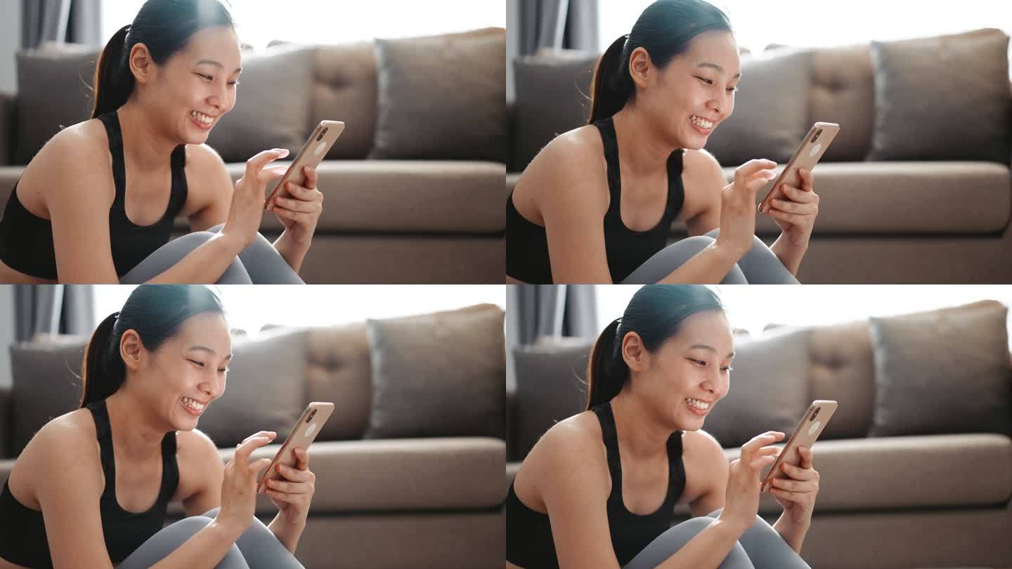 运动妇女在家里使用智能手机