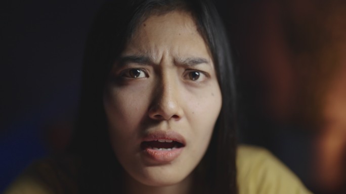 视频中，一名年轻女子面带悲伤和担忧的表情思考。