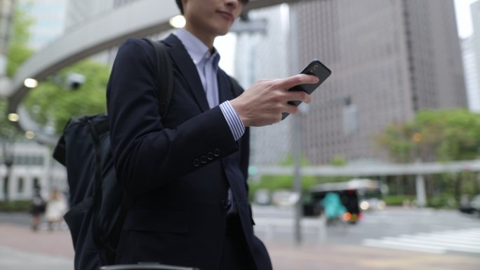 商人在城市使用智能手机-向上倾斜